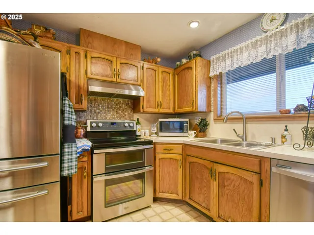 a kitchen with kitchen island granite countertop a sink appliances cabinets and furniture