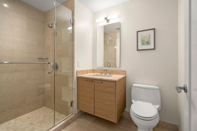 a bathroom with a granite countertop toilet a sink and mirror