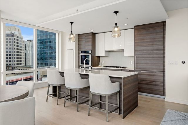 a kitchen with kitchen island a stove a table and chairs in it