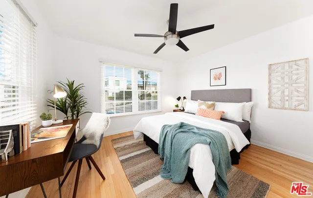 a bedroom with a large bed and a potted plant