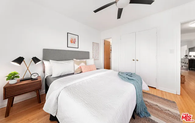 a bed room with bed and a painting on the wall