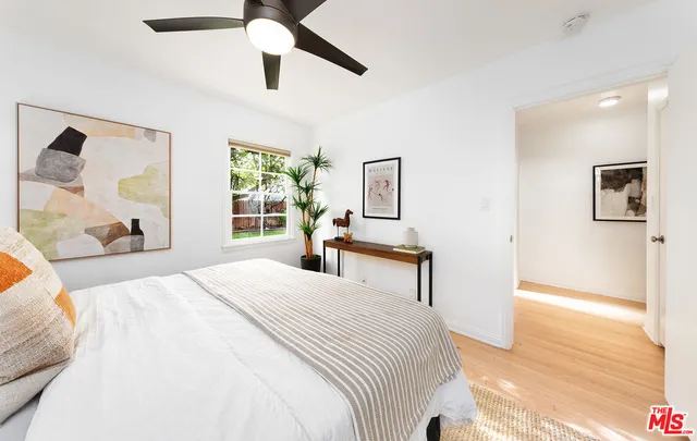 a bedroom with a bed and wooden floor