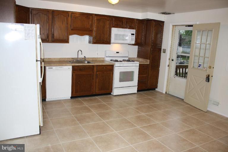 7866 Kavanagh Road Dundalk, MD 21222 - Photo 5 of 14 a kitchen with a stove a refrigerator and a sink