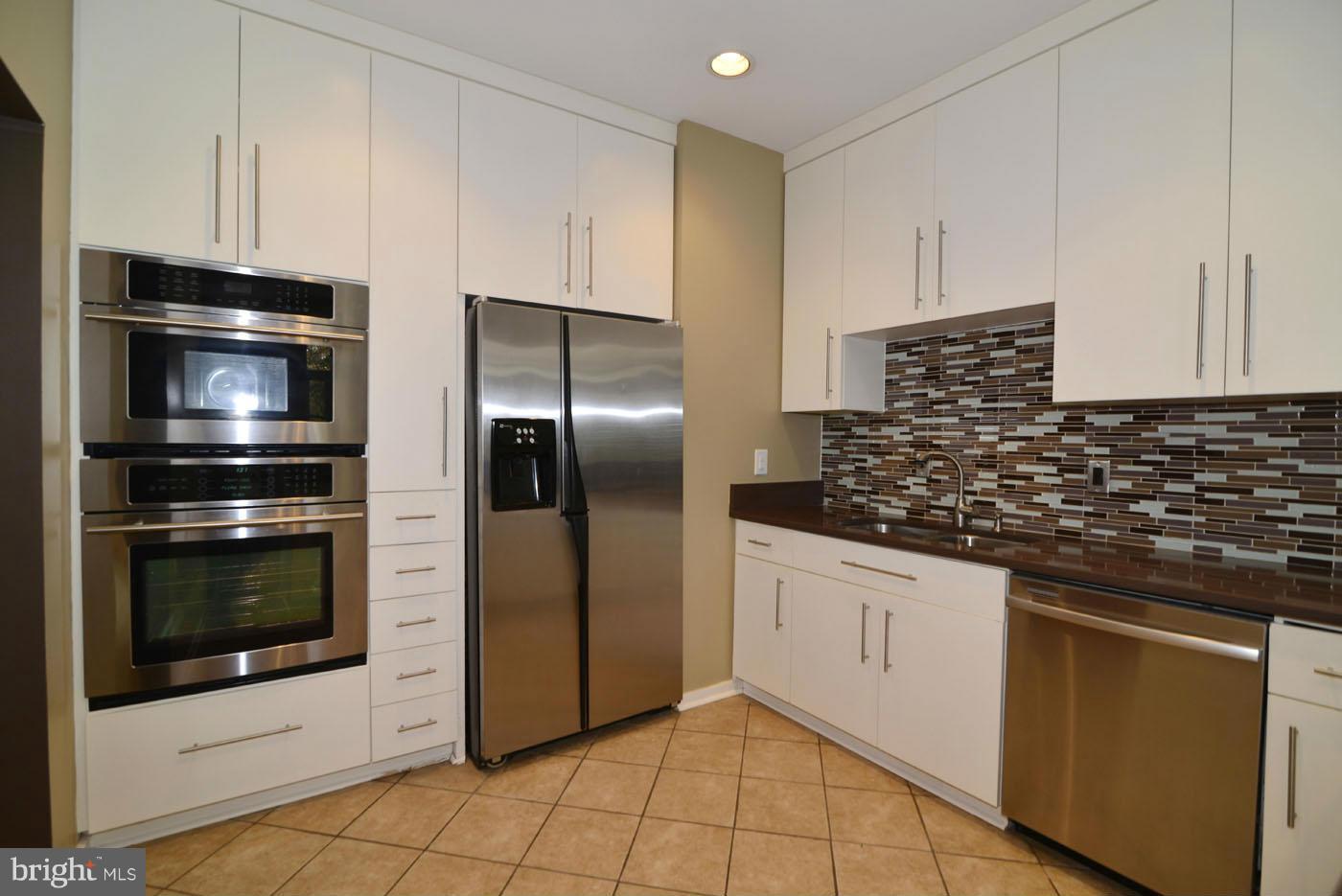 2040 Beacon Place Reston, VA 20191 - Photo 11 of 30 a kitchen with granite countertop a refrigerator and a stove