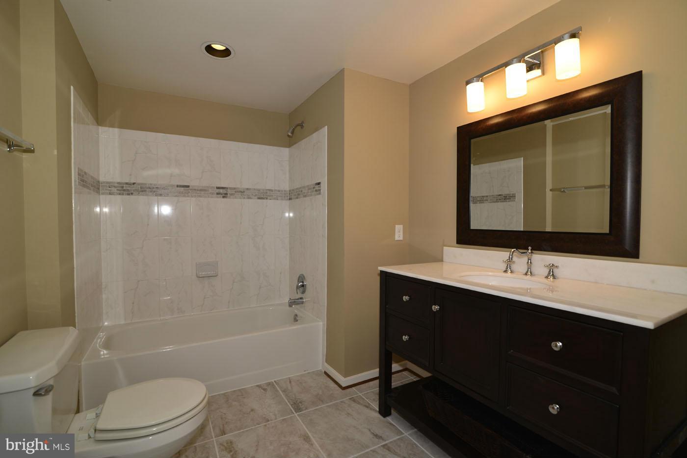 2040 Beacon Place Reston, VA 20191 - Photo 17 of 30 a bathroom with a toilet a sink a mirror a bathtub and shower