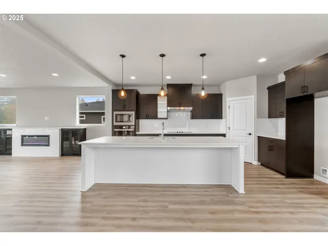 a view of empty room with kitchen and fireplace