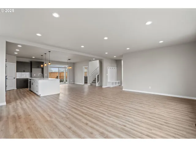 a large white kitchen with kitchen island a sink stainless steel appliances and cabinets