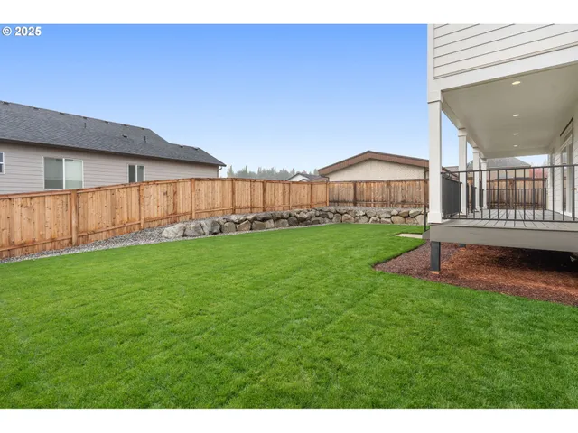 a view of a backyard with wooden fence