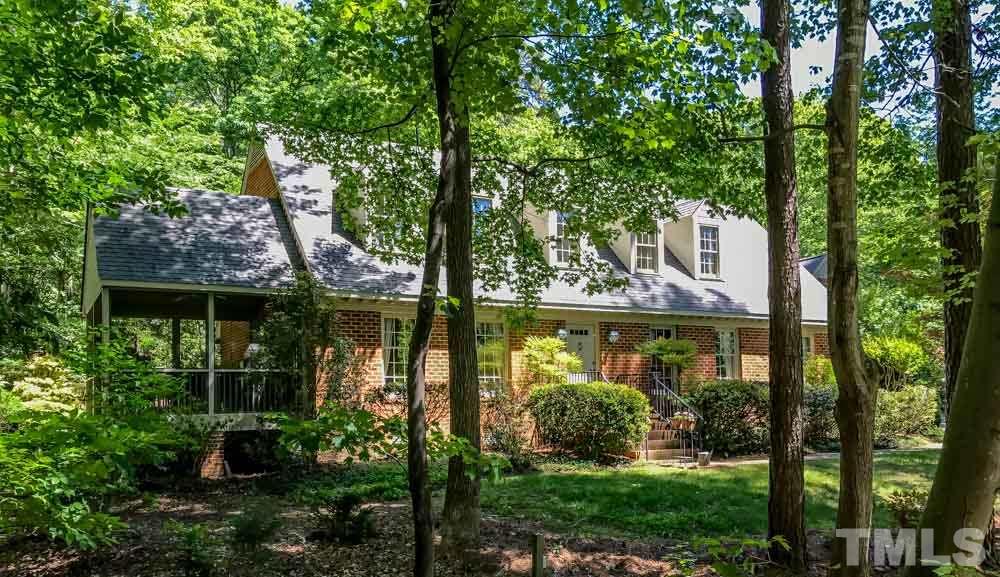 a view of a brick house with a yard and potted plants