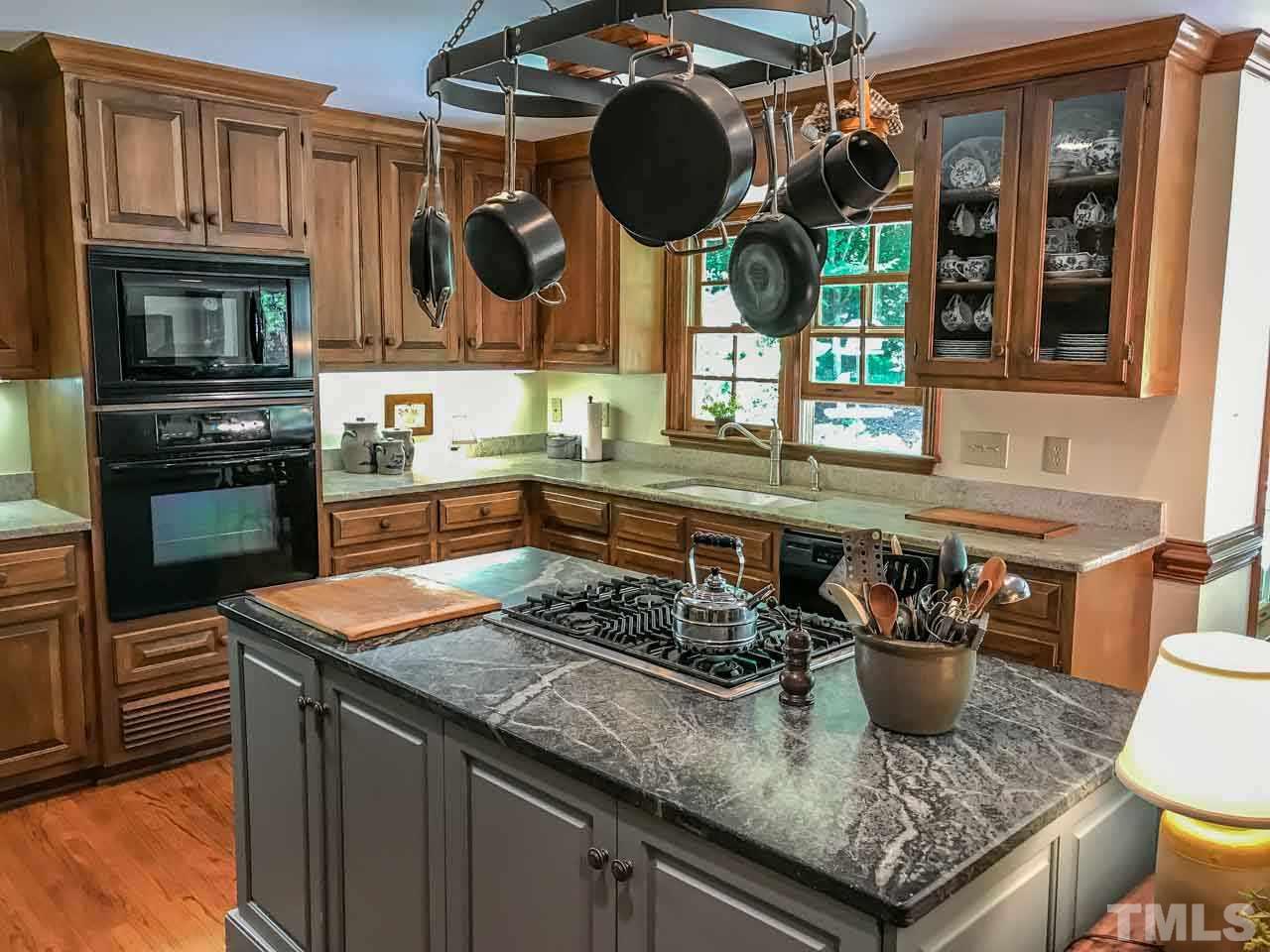 1806 Grande Oaks Road Durham, NC 27712 - Photo 14 of 25 a kitchen with stainless steel appliances granite countertop a sink a stove and a wooden cabinets