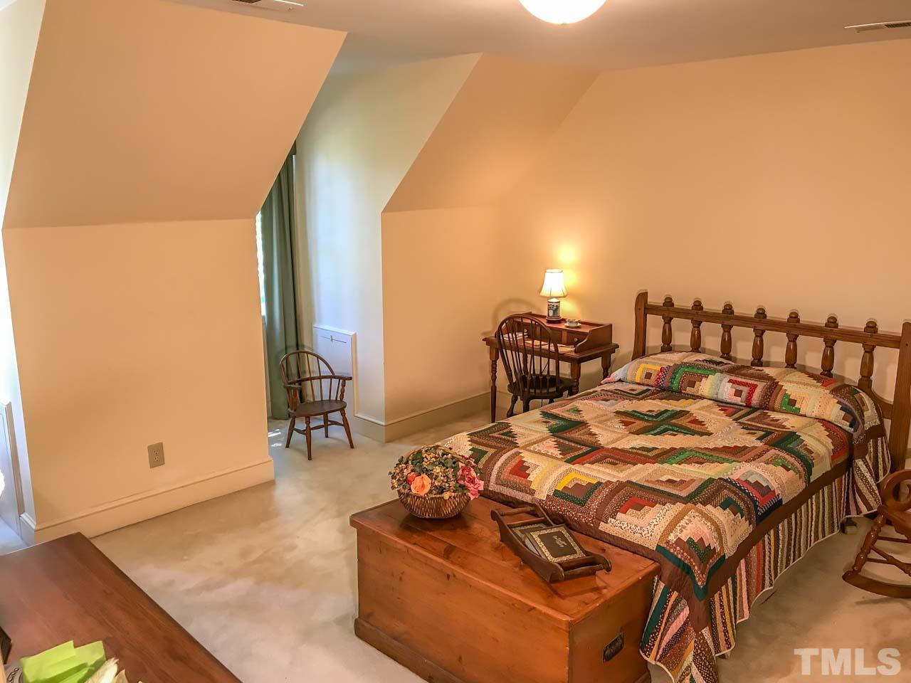 1806 Grande Oaks Road Durham, NC 27712 - Photo 24 of 25 a bed sitting in a bedroom next to a window with lamp