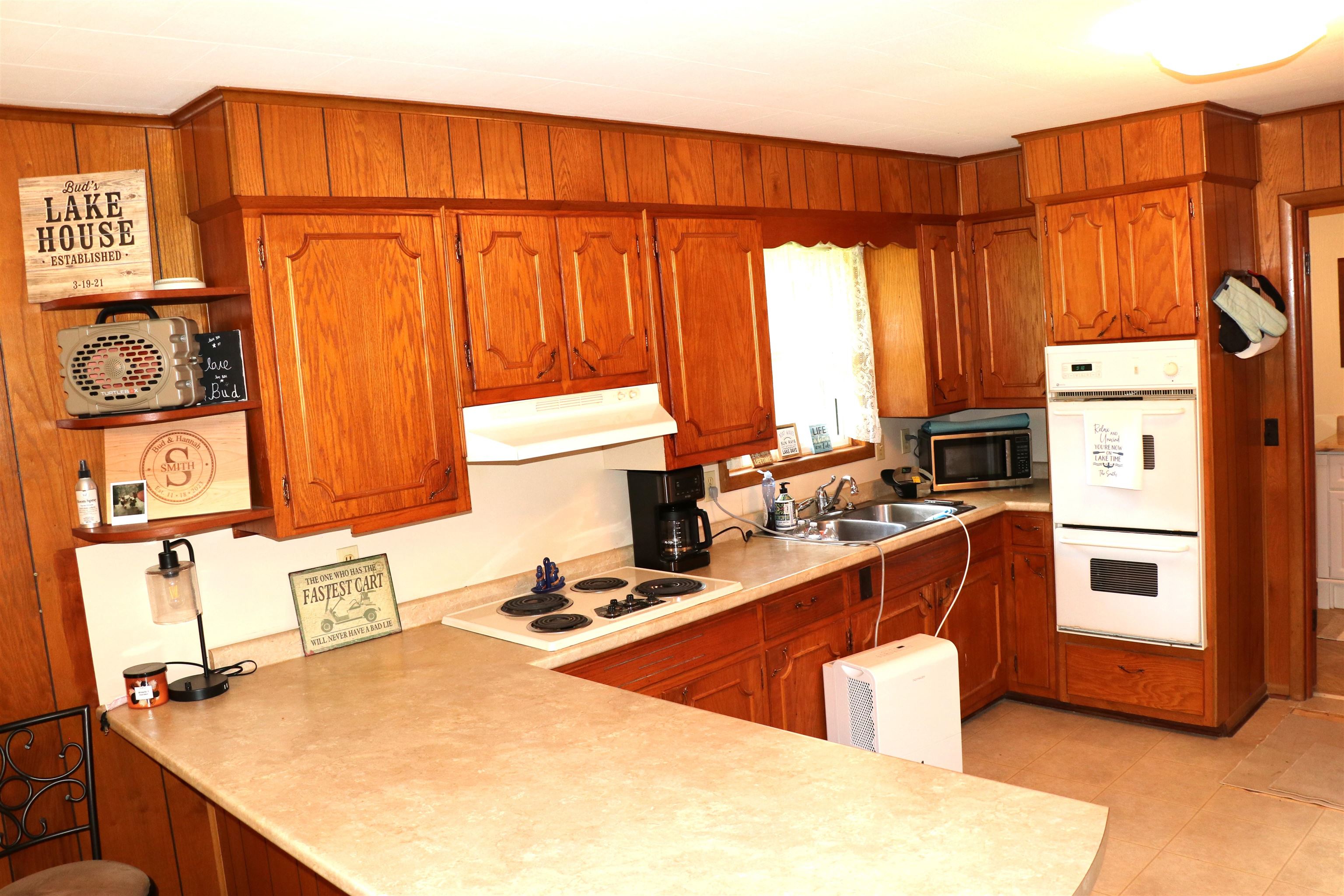 160 Patrick Drive Springville, TN 38256 - Photo 6 of 34 Kitchen featuring wood-paneled walls, extensive wood cabinetry, and a double basin sink