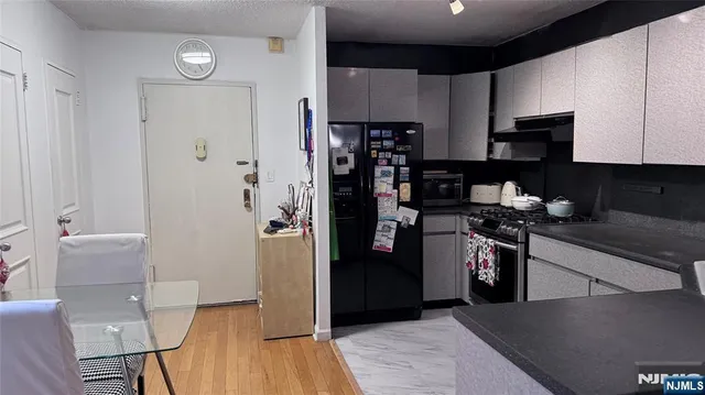 a kitchen with a refrigerator and a stove top oven