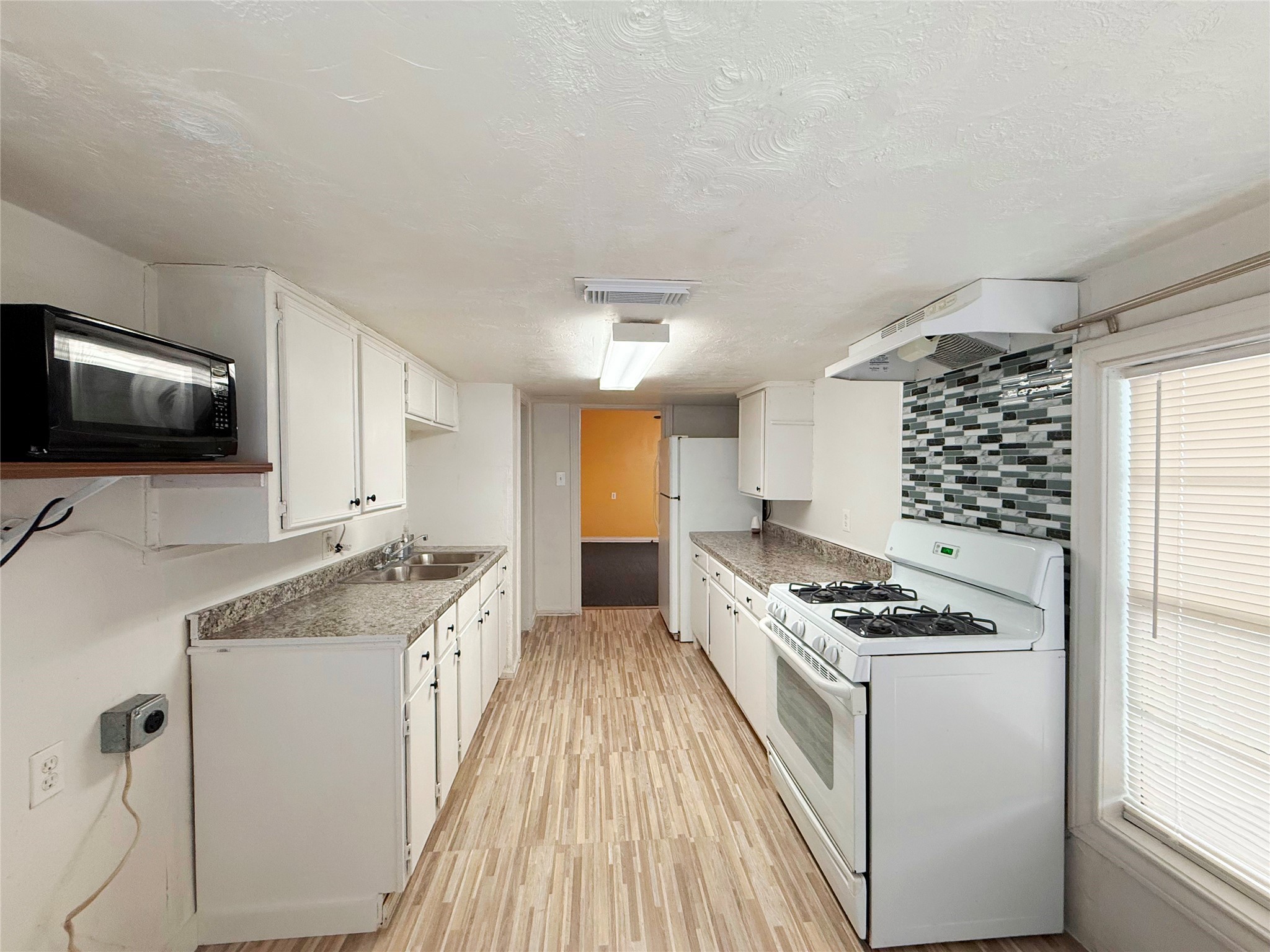 723 West 27th Street Houston, TX 77008 - Photo 7 of 22 a kitchen with granite countertop a sink stove and cabinets