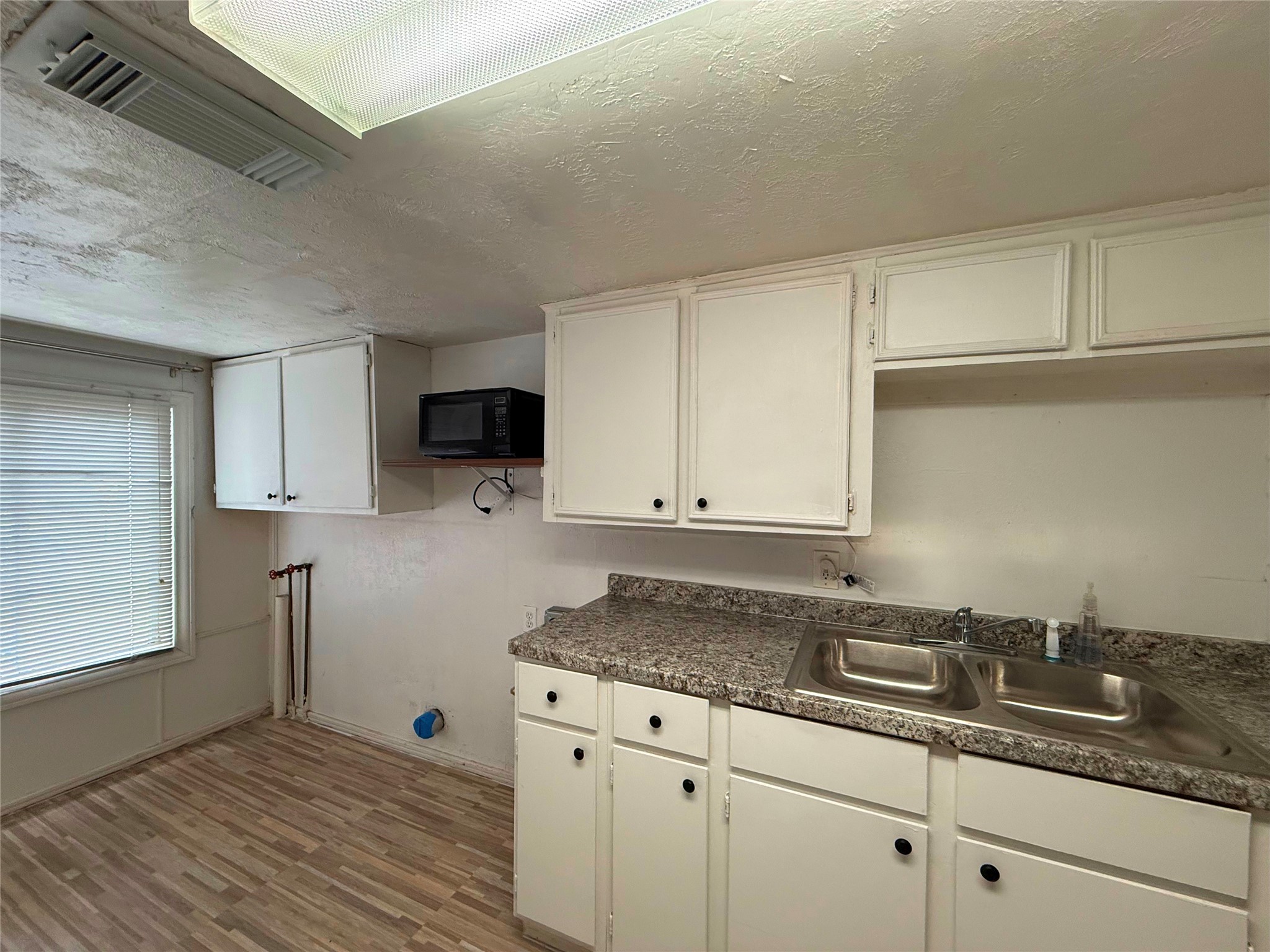 723 West 27th Street Houston, TX 77008 - Photo 8 of 22 a kitchen with granite countertop white cabinets and a sink