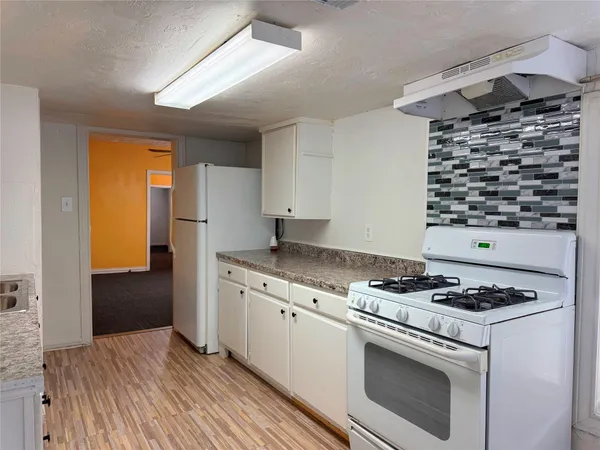 a kitchen with granite countertop a stove and a refrigerator