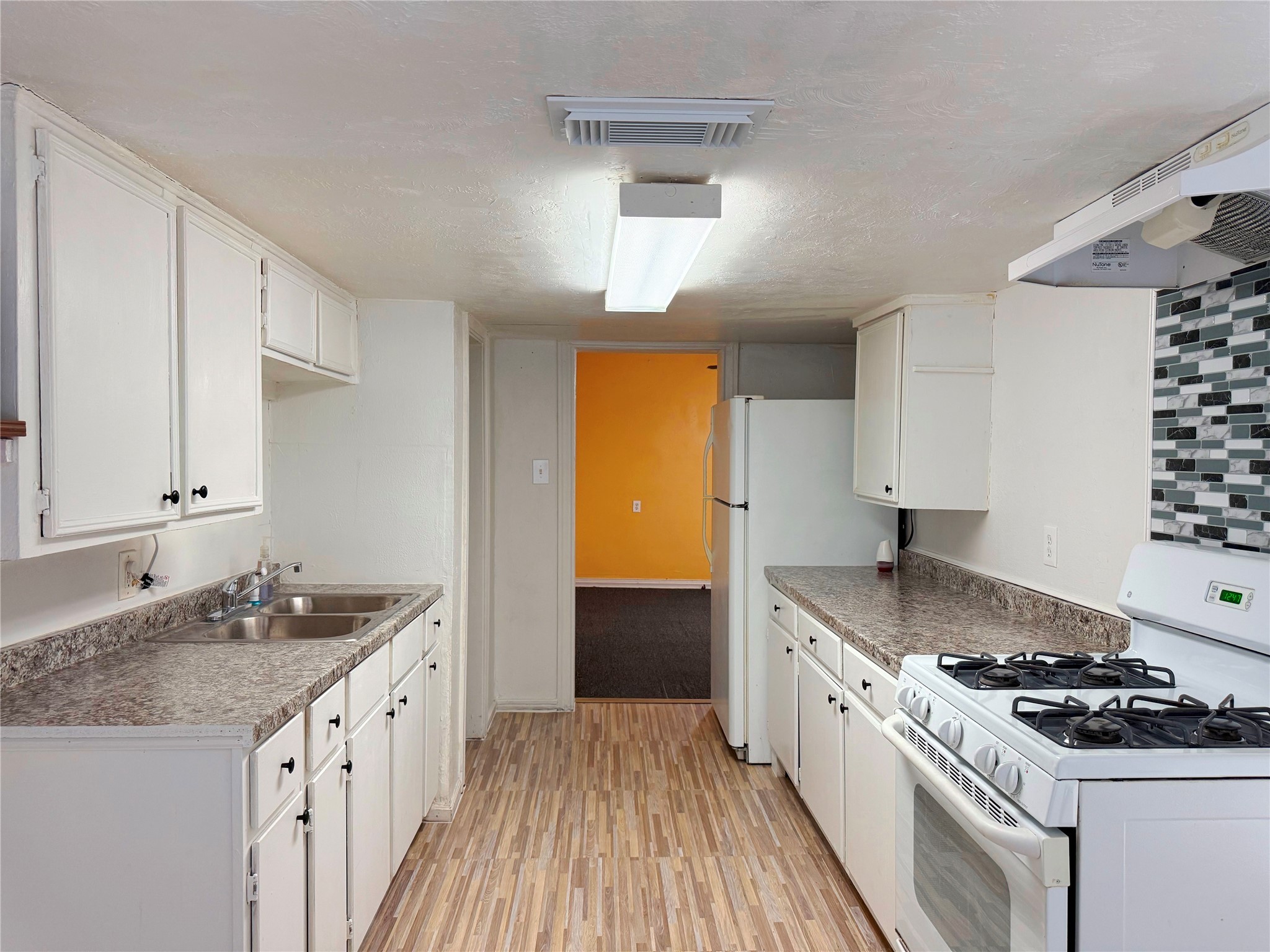 723 West 27th Street Houston, TX 77008 - Photo 10 of 22 a kitchen with granite countertop a sink stove and cabinets