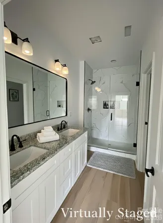 a spacious bathroom with a granite countertop sink mirror and shower