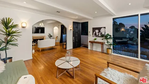 a living room with fireplace furniture and a wooden floor