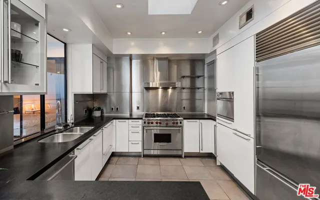 a kitchen with stainless steel appliances granite countertop a sink and cabinets