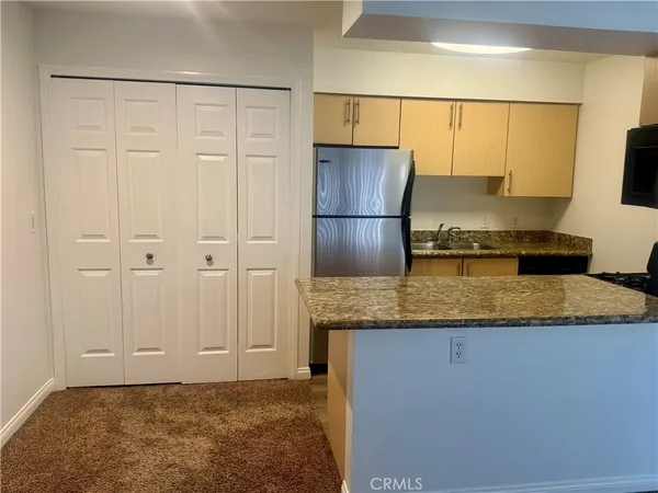 a kitchen with kitchen island granite countertop cabinets and refrigerator