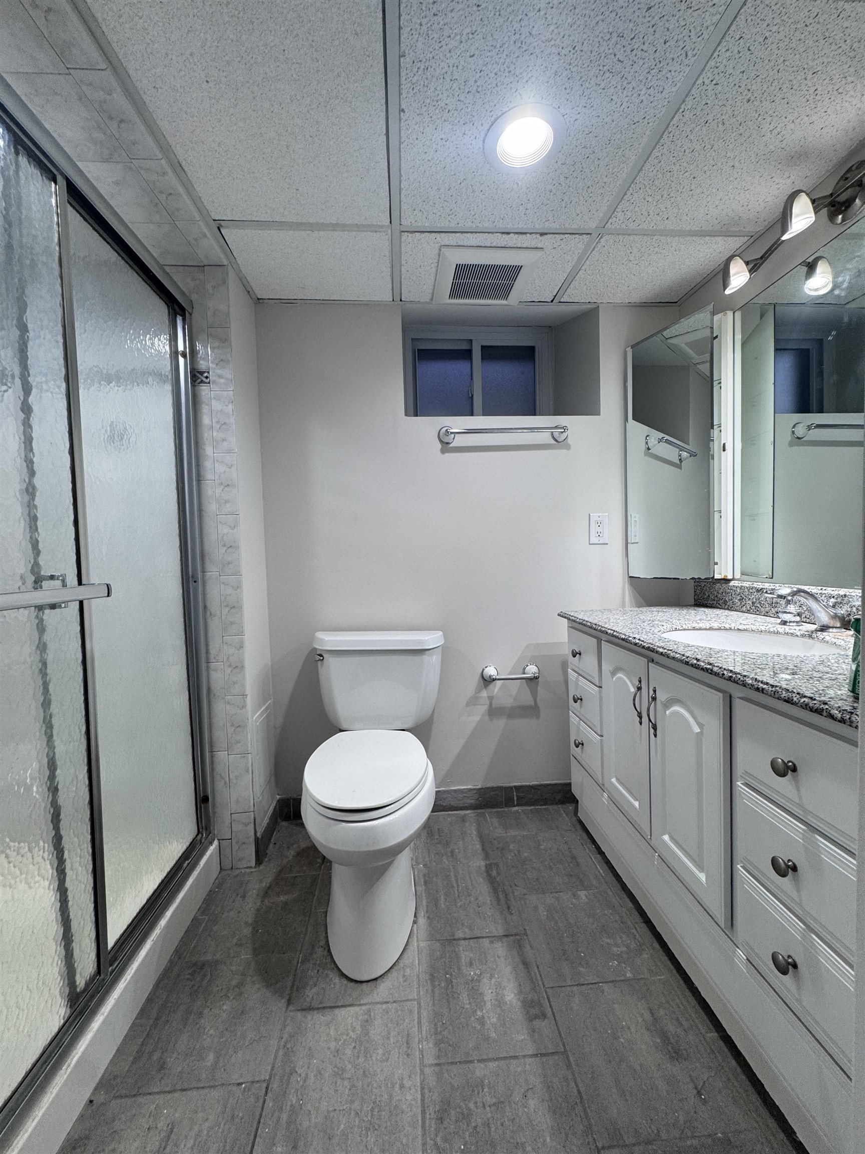 510 Shaler Boulevard, Unit 1 Ridgefield, NJ 07657 - Photo 9 of 10 a bathroom with a granite countertop toilet a sink a mirror and vanity