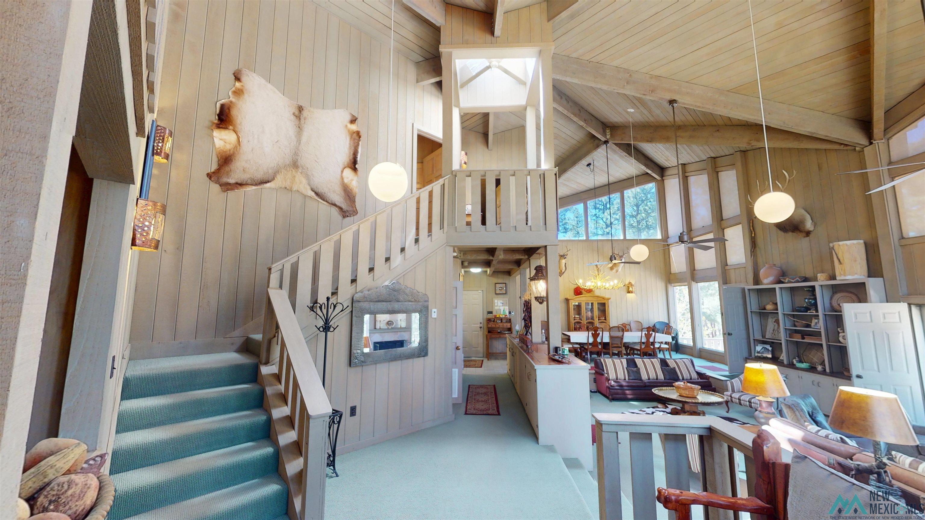 39 Alta Vista Rociada, NM 87742 - Photo 22 of 54 Vaulted wood-paneled ceilings with exposed beams and a large window array