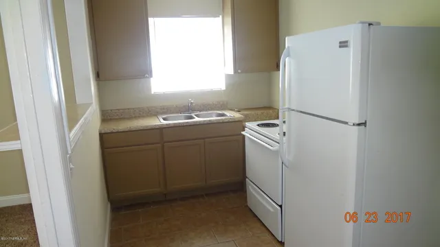 a white refrigerator freezer and a stove sitting inside of a kitchen