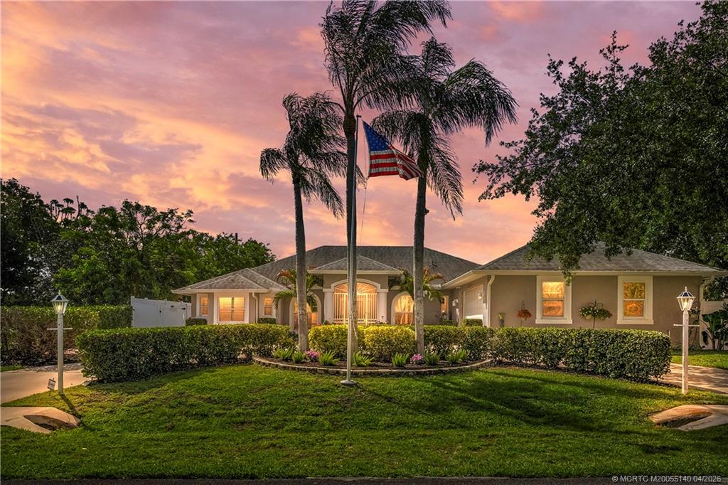 5688 Southeast Pot O Gold Place Stuart, FL 34997 - Photo 1 of 40 a front view of a house with a garden