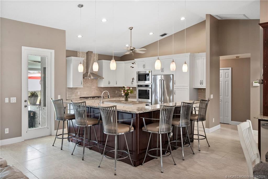 5688 Southeast Pot O Gold Place Stuart, FL 34997 - Photo 13 of 40 a large kitchen with a table and chairs