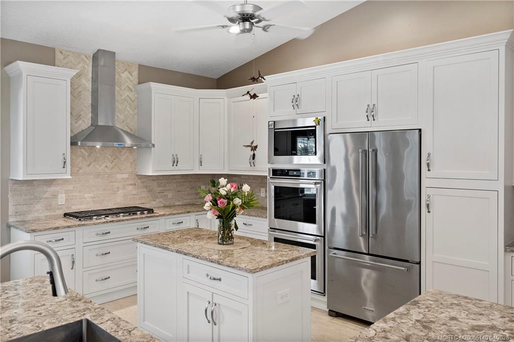 5688 Southeast Pot O Gold Place Stuart, FL 34997 - Photo 14 of 40 a kitchen with granite countertop a refrigerator stove and sink
