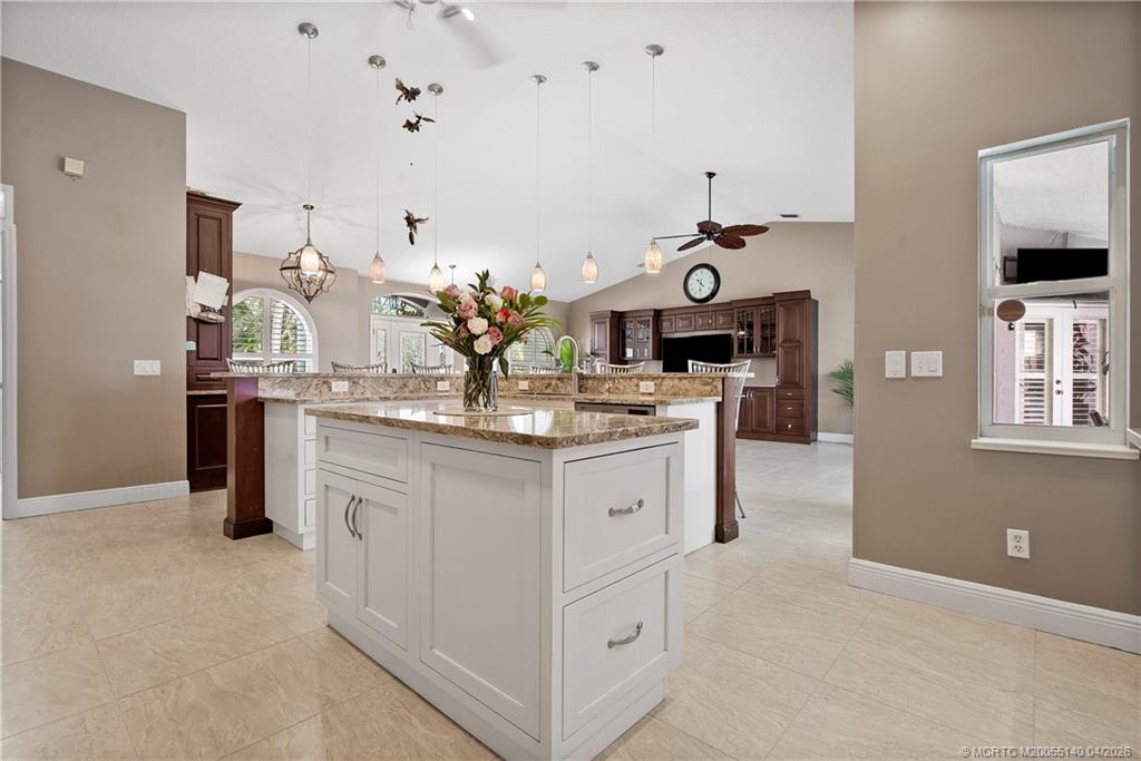 5688 Southeast Pot O Gold Place Stuart, FL 34997 - Photo 18 of 40 a kitchen with kitchen island white cabinets and sink