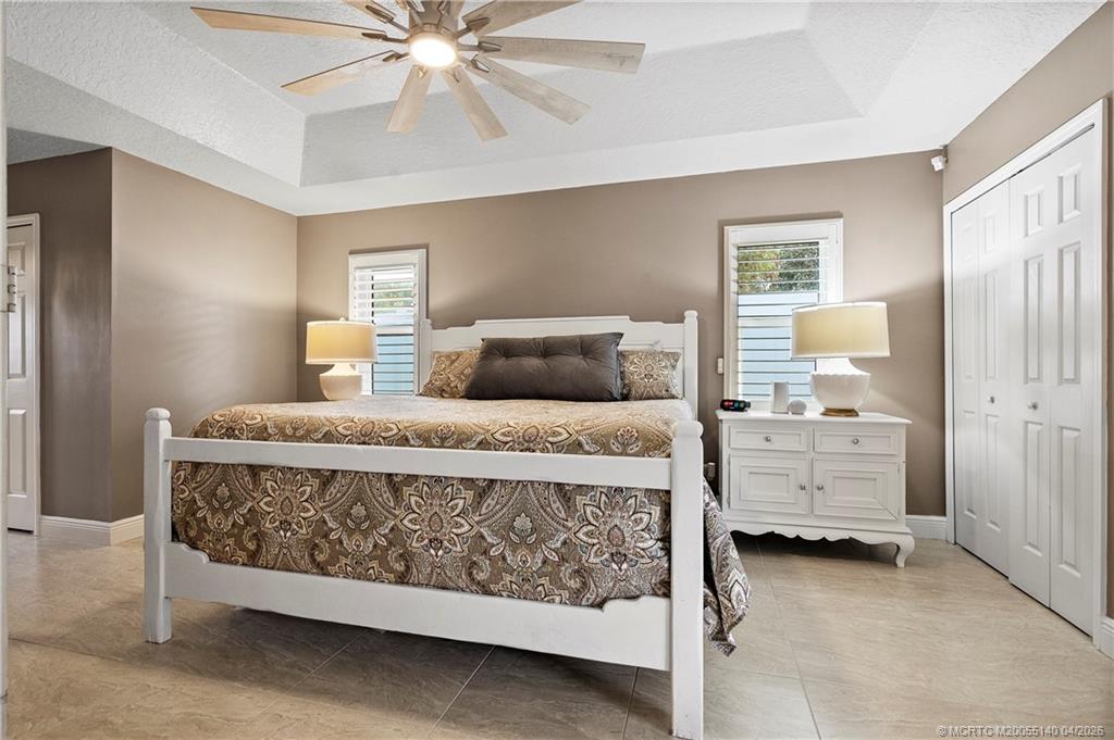 5688 Southeast Pot O Gold Place Stuart, FL 34997 - Photo 19 of 40 a bedroom with a bed and a cabinets