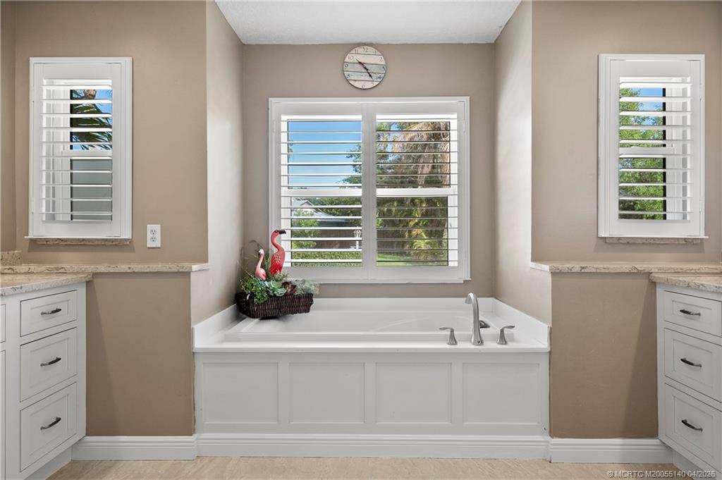 5688 Southeast Pot O Gold Place Stuart, FL 34997 - Photo 21 of 40 a bathroom with a bathtub and a window