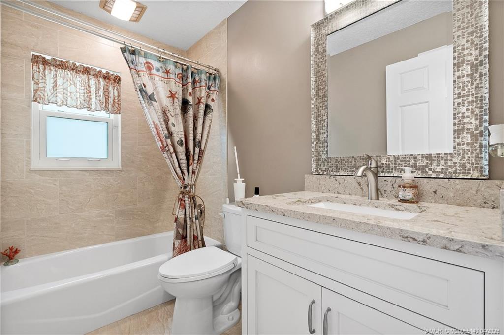 5688 Southeast Pot O Gold Place Stuart, FL 34997 - Photo 25 of 40 a bathroom with a sink a toilet and a bathtub
