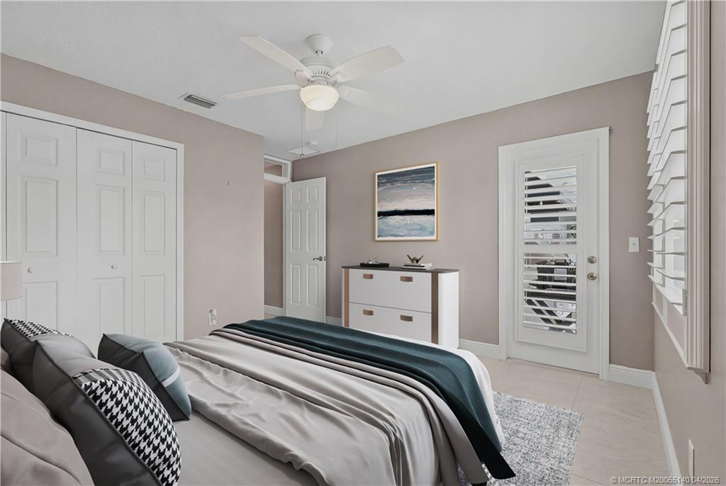 5688 Southeast Pot O Gold Place Stuart, FL 34997 - Photo 27 of 40 a bedroom with a bed and a window