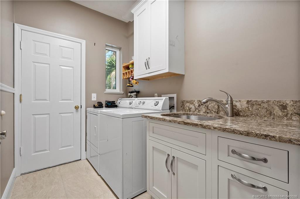 5688 Southeast Pot O Gold Place Stuart, FL 34997 - Photo 28 of 40 a utility room with cabinets washer and dryer