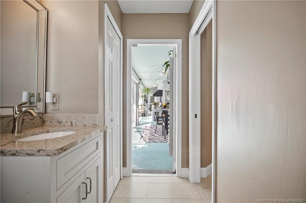 5688 Southeast Pot O Gold Place Stuart, FL 34997 - Photo 29 of 40 a bathroom with a granite countertop sink and a mirror