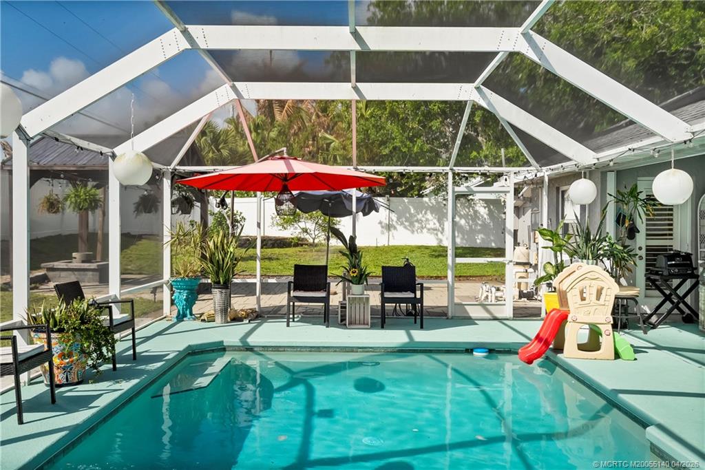 5688 Southeast Pot O Gold Place Stuart, FL 34997 - Photo 35 of 40 an outdoor sitting area with furniture and umbrella
