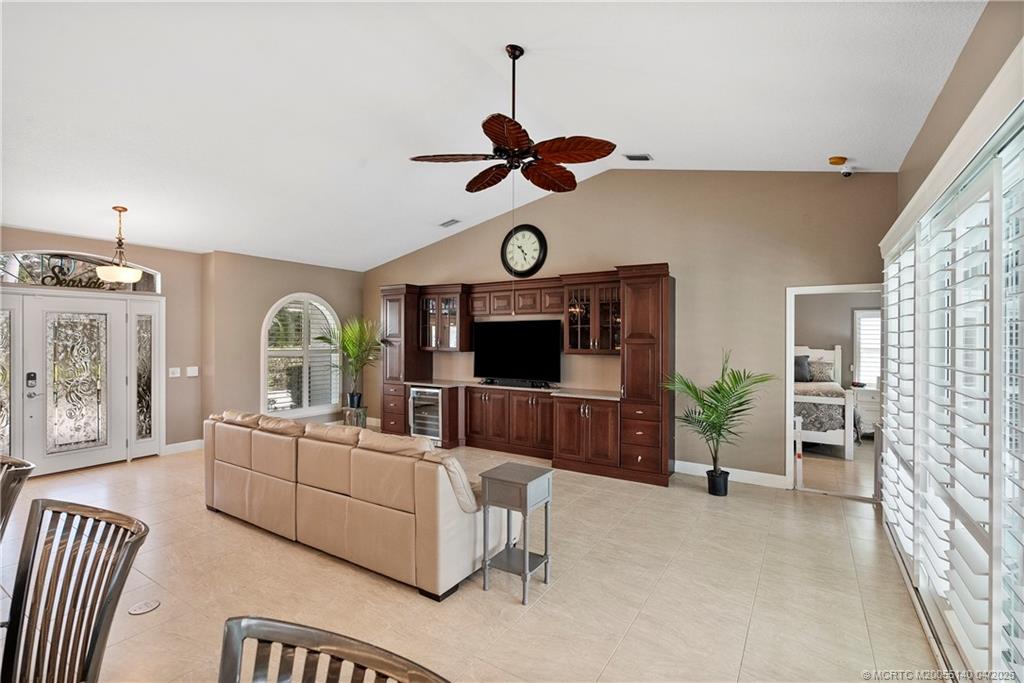 5688 Southeast Pot O Gold Place Stuart, FL 34997 - Photo 9 of 40 a living room with furniture a flat screen tv and a window