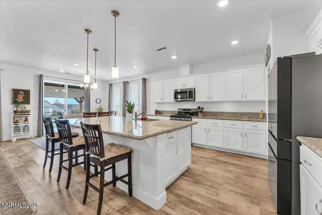 a kitchen with stainless steel appliances granite countertop a sink stove and cabinets