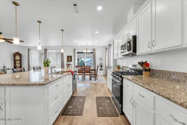 a kitchen with stainless steel appliances granite countertop a stove oven and a refrigerator