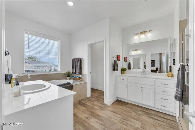 a spacious bathroom with a double vanity sink toilet and mirror
