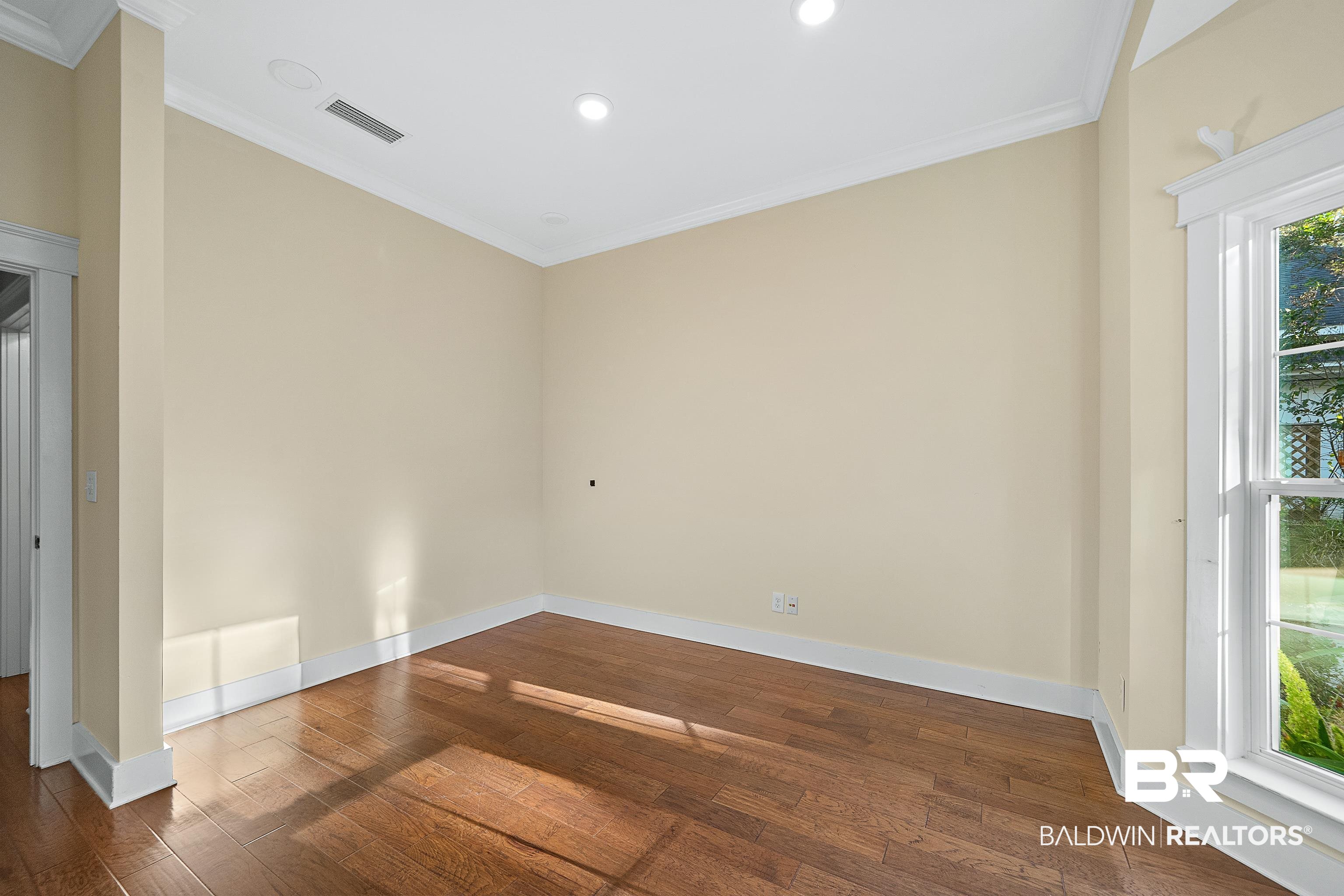 356 Liberty Street Fairhope, AL 36532 - Photo 19 of 39 Empty room with crown molding, dark wood-type flooring, and recessed lighting