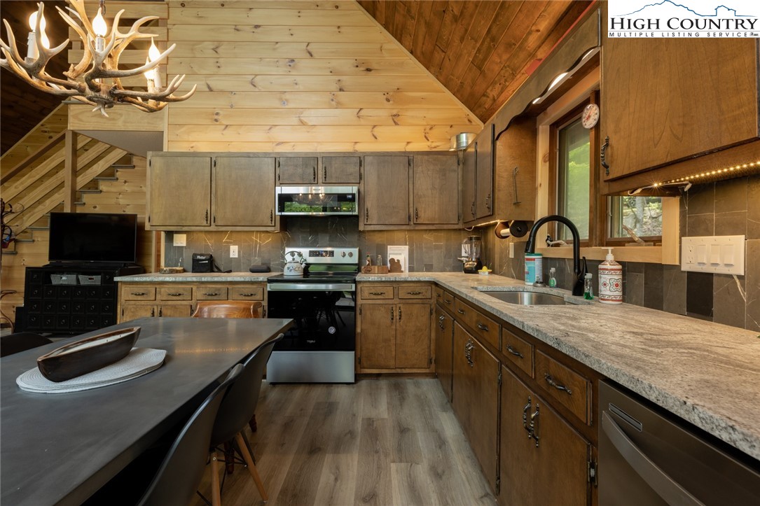 495 Horseshoe Ridge Road East Deep Gap, NC 28618 - Photo 14 of 33 a kitchen with stainless steel appliances granite countertop a sink a stove and a wooden cabinets