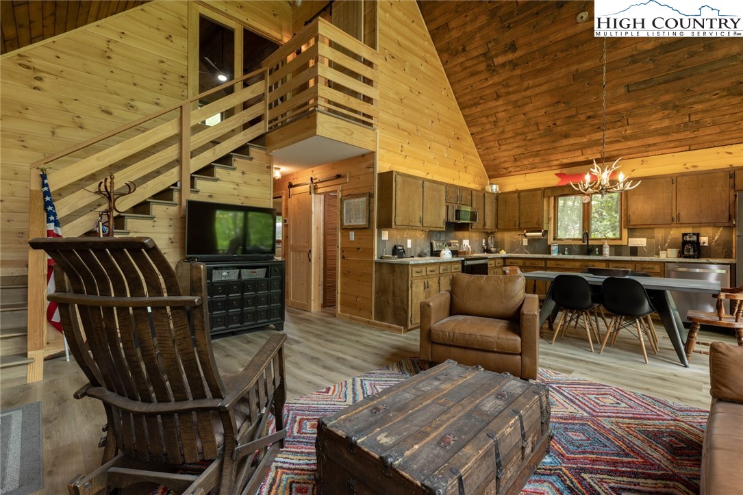 495 Horseshoe Ridge Road East Deep Gap, NC 28618 - Photo 15 of 33 a view of a patio with couches table and chairs with wooden floor