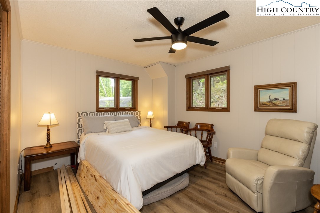 495 Horseshoe Ridge Road East Deep Gap, NC 28618 - Photo 21 of 33 a bedroom with a bed and a chandelier