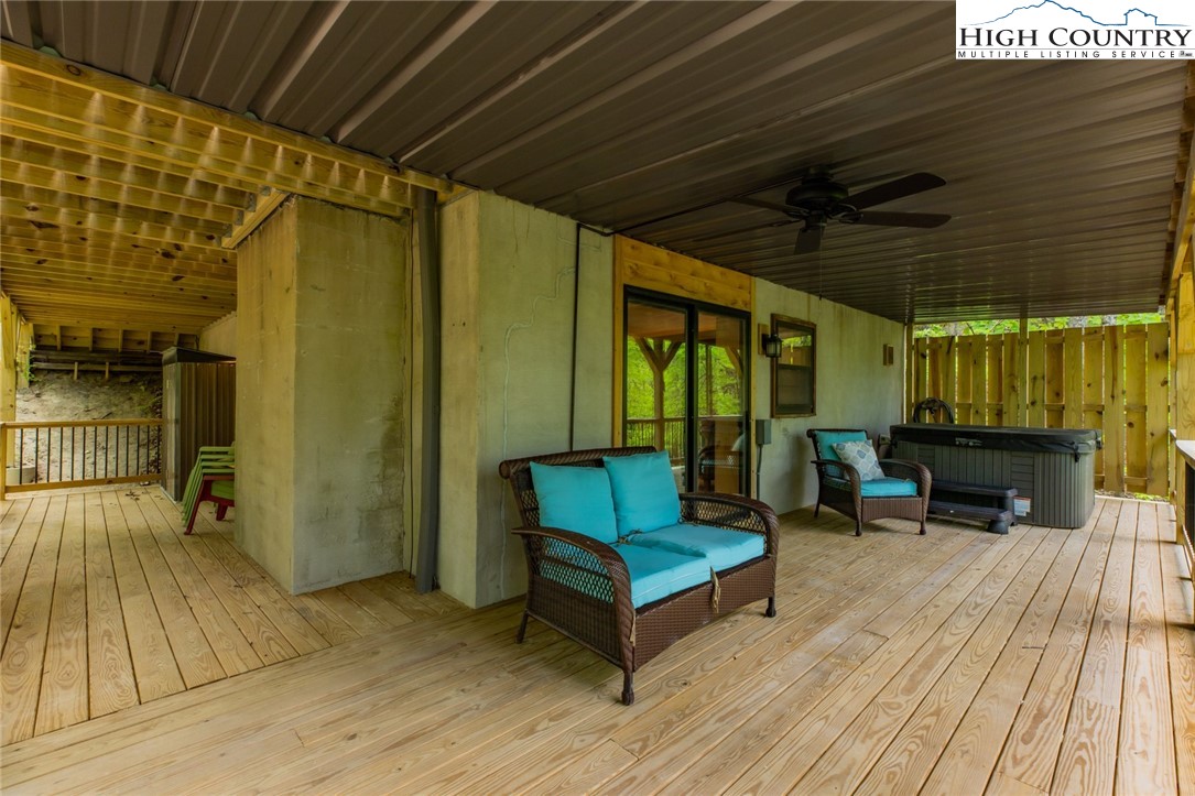 495 Horseshoe Ridge Road East Deep Gap, NC 28618 - Photo 31 of 33 a view of a patio with table and chairs with wooden floor and fence