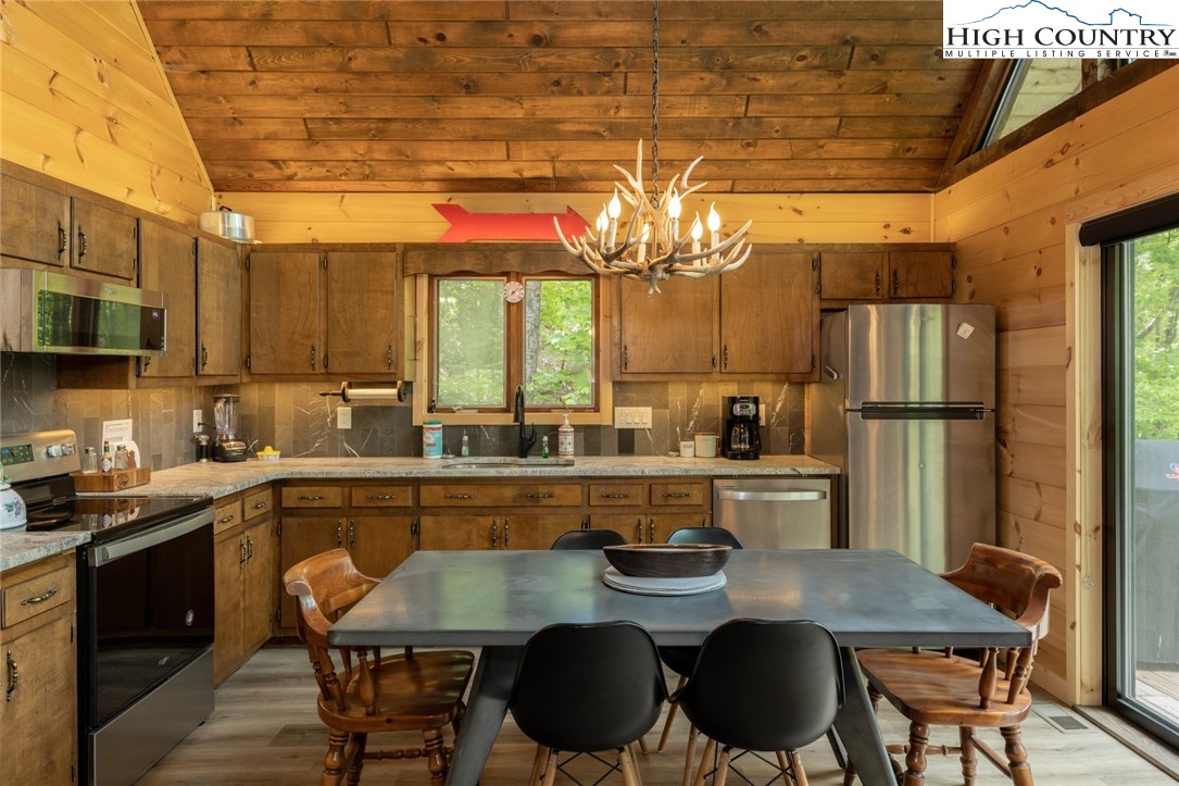 495 Horseshoe Ridge Road East Deep Gap, NC 28618 - Photo 10 of 33 a kitchen with a table chairs stove and cabinets
