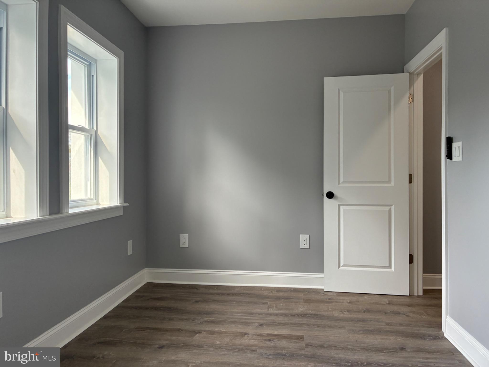 5812 Willows Avenue Philadelphia, PA 19143 - Photo 16 of 27 a view of an empty room with wooden floor and a window